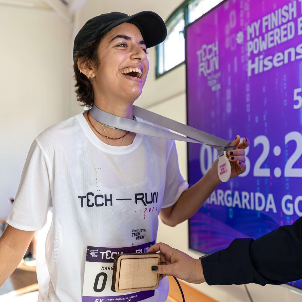 runner wearing white t-shirt proud of it race time displayed at a big screen
